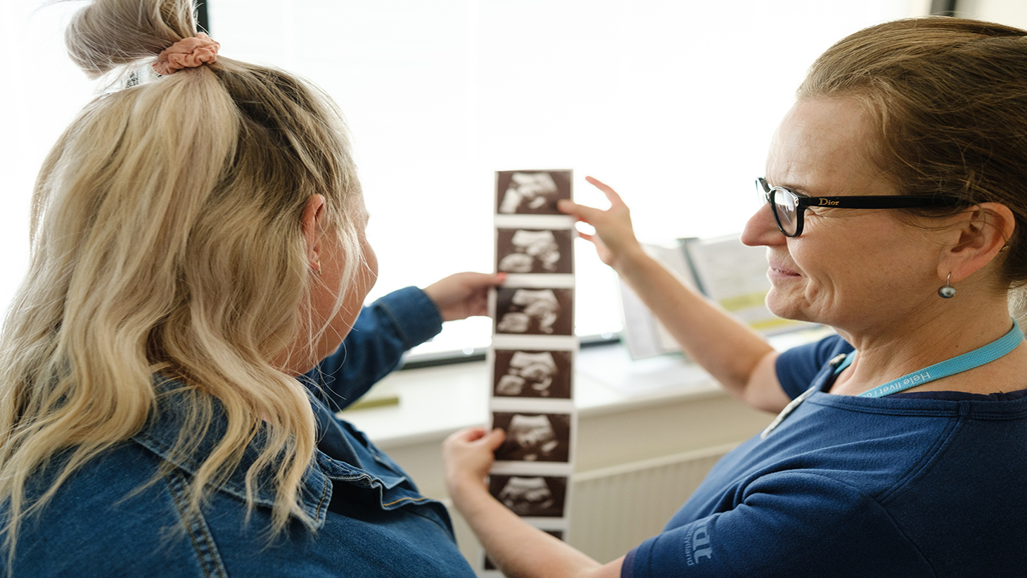 Jordemoder viser scanningsbilleder for gravid
